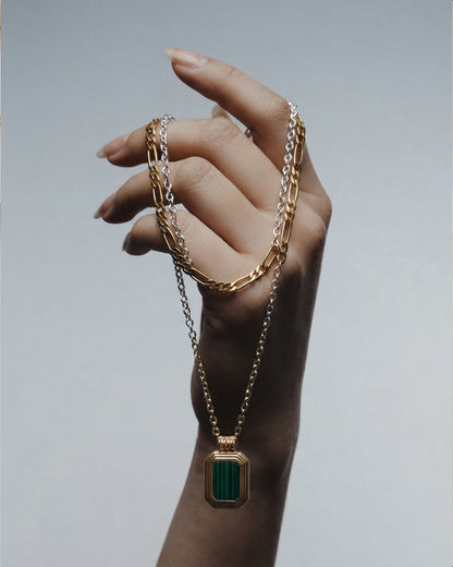 Layered gold chain necklace with a green malachite pendant.